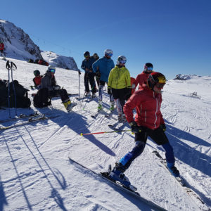 a line of instructors waiting for their turn to ski a giant slalom in preparation for their Eurotest